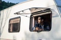 Asian young man feeling relax on camper van drinking coffee in the morning with happiness and smile on vacation. Male traveler loo Royalty Free Stock Photo