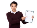 Asian young man finger point to blank page of clipboard Royalty Free Stock Photo