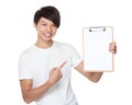 Asian young man finger point to blank page of clipboard Royalty Free Stock Photo