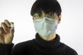 Asian young man in glasses, protective mask against covid-19 with pill in hand Royalty Free Stock Photo