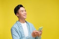 Asian young man holding smartphone doing winning gesture holding mobile phone Royalty Free Stock Photo