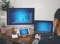 Asian young man interacting with laptops, phones, and tablets with featuring stock tickers or graphs, cryptocurrency and new tradi Royalty Free Stock Photo