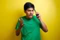 Asian young man looks mad while in phone call Royalty Free Stock Photo