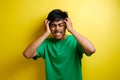 Asian young man looks upset and squeezing his heads Royalty Free Stock Photo