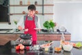 Asian young man in Red apron. Cooking for food in the kitchen at Home Royalty Free Stock Photo