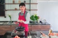 Asian young man  in Red apron, Smiling. Holding fried sausage on dishes for  food Royalty Free Stock Photo