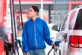 Asian young man refuelling in self service gas station. refuel in tank automobile. transportation concept