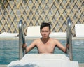 Asian young man relaxing on a swimming pool Royalty Free Stock Photo