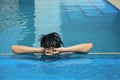 Asian young man relaxing on a swimming pool Royalty Free Stock Photo