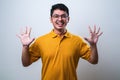 Asian young man showing and pointing up with fingers number ten Royalty Free Stock Photo