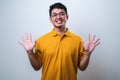 Asian young man showing and pointing up with fingers number ten Royalty Free Stock Photo