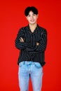 Asian young man smart and handsome wear black-white t-shirt and jean standing folded arms crossed and look at camera. He look feel Royalty Free Stock Photo