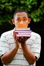 Asian young man with stack of books on hands
