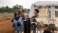 Asian young man two persons sitting enjoy coffee drink near a camping tent in the morning time, coffee drink relaxing on the