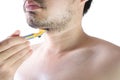 Asian young man using a razor shaving his beard. Do not use cream. on white background and clipping path. Clean face treatment Royalty Free Stock Photo