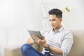 asian young man using tablet pc at home Royalty Free Stock Photo