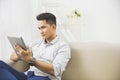 Asian young man using tablet pc at home Royalty Free Stock Photo