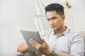 Asian young man using tablet pc at home Royalty Free Stock Photo
