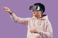 Asian young man using virtual reality headset isolated over violet background Royalty Free Stock Photo