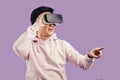 Asian young man using virtual reality headset over violet background Royalty Free Stock Photo