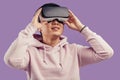 Asian young man using virtual reality headset isolated over violet background Royalty Free Stock Photo
