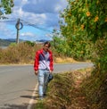 An Asian young man walking on rural road Royalty Free Stock Photo