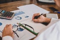 Asian young man in white shirt holding pen working ,Calculate tax lead to liquidation, With Sunset light vintage style Royalty Free Stock Photo