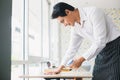 Asian young man white shirt wipe cleaning table with spray alcohol for sterilize in restaurant. Royalty Free Stock Photo