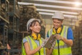 Asian young man and women worker team engineer working help support together using tablet happy smile to work in factory industry Royalty Free Stock Photo