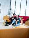 Asian young man holding and giving lock key door to pretty woman after unpacking cardboard box and relocation to new modern Royalty Free Stock Photo