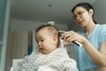 Asian Young Mother cutting her little baby son hair at home Royalty Free Stock Photo