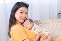 Asian young mother holding newborn baby, Beautiful mom of nursing. Adorable little boy sleeping on mother`s chest. Happy woman Royalty Free Stock Photo