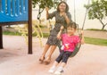 Asian young mother play on a swing with her adorable little daughter at the park, mom and little have fun and happy. Royalty Free Stock Photo