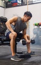 Asian young muscular fit strong body sporty athletic male fitness model in workout sleeveless sportswear holding lifting metal Royalty Free Stock Photo