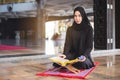 Asian young muslim woman reading Quran. Royalty Free Stock Photo