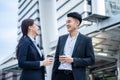 Asian young office businesspeople stand outdoor in city with confident. Formal working partner man and woman hold cup of coffee,
