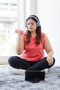 Asian young overweight oversized fat chubby plump healthy fit female sportswoman in sportswear wears headphones sitting on carpet