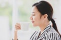 Asian young pretty beautiful successful friendly businesswoman smile holding cup of hot coffee in hand in rest relax break time Royalty Free Stock Photo