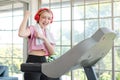 Asian young pretty cheerful happy healthy fitness girl in sexy sportswear with headphones listening to music playlist walking Royalty Free Stock Photo