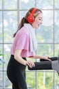 Asian young pretty cheerful happy healthy fitness girl in sexy sportswear with headphones listening to music playlist walking Royalty Free Stock Photo