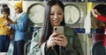 Asian young pretty and stylish girl in yellow glasses standing in laundry service room and tapping on smartphone.