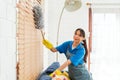 Asian young professional cleaning service woman worker working in the house. The girl cleans the curtain and window. Royalty Free Stock Photo