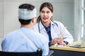 Asian young professional female practitioner doctor in white lab coat with stethoscope holding skull model showing explaining to Royalty Free Stock Photo