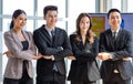 Asian young professional successful male and female businessmen and businesswomen in formal business suit standing side by side