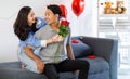 Asian young romantic lover couple female girlfriend holding red roses bouquet hugging cuddling surprising male boyfriend