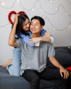 Asian young romantic lover couple female girlfriend hugging cuddling surprising male boyfriend celebration anniversary on cozy