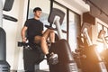 Asian young sport man riding stationary bicycle in fitness gym. Man working out on spinning bikes in gym. People lifestyles and Royalty Free Stock Photo