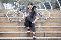 asian young sport woman in sportswear sitting on the stairs with bicycle and showing thumbs up . girl taking a rest and relaxing Royalty Free Stock Photo