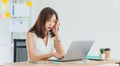 Asian young stressed depressed tired exhausted female businesswoman employee in casual business wear sitting working overtime with Royalty Free Stock Photo