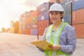 Asian young teen happy worker checking stock in shipping port work manage import export cargo containers